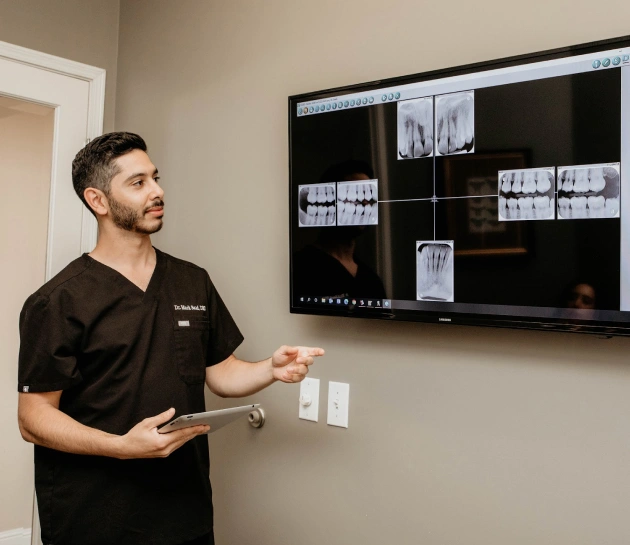 dr. anthony mark saad showing digital x-ray to a patient