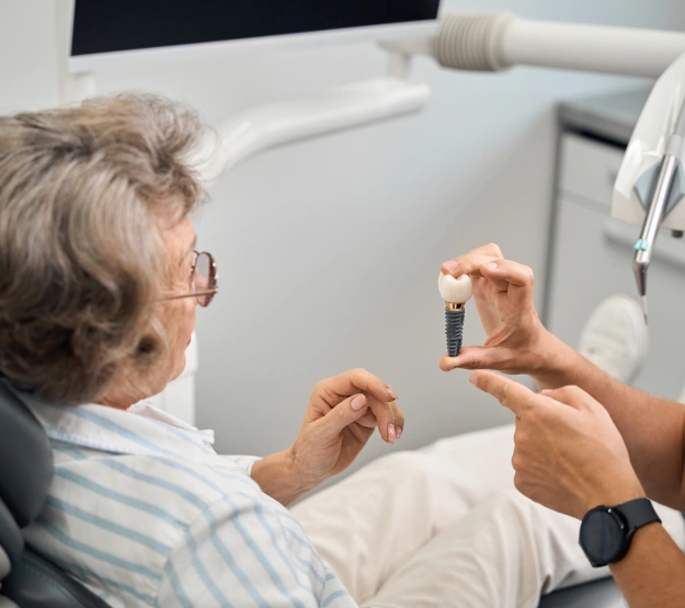 Dentist showing a dental crown model to a patient